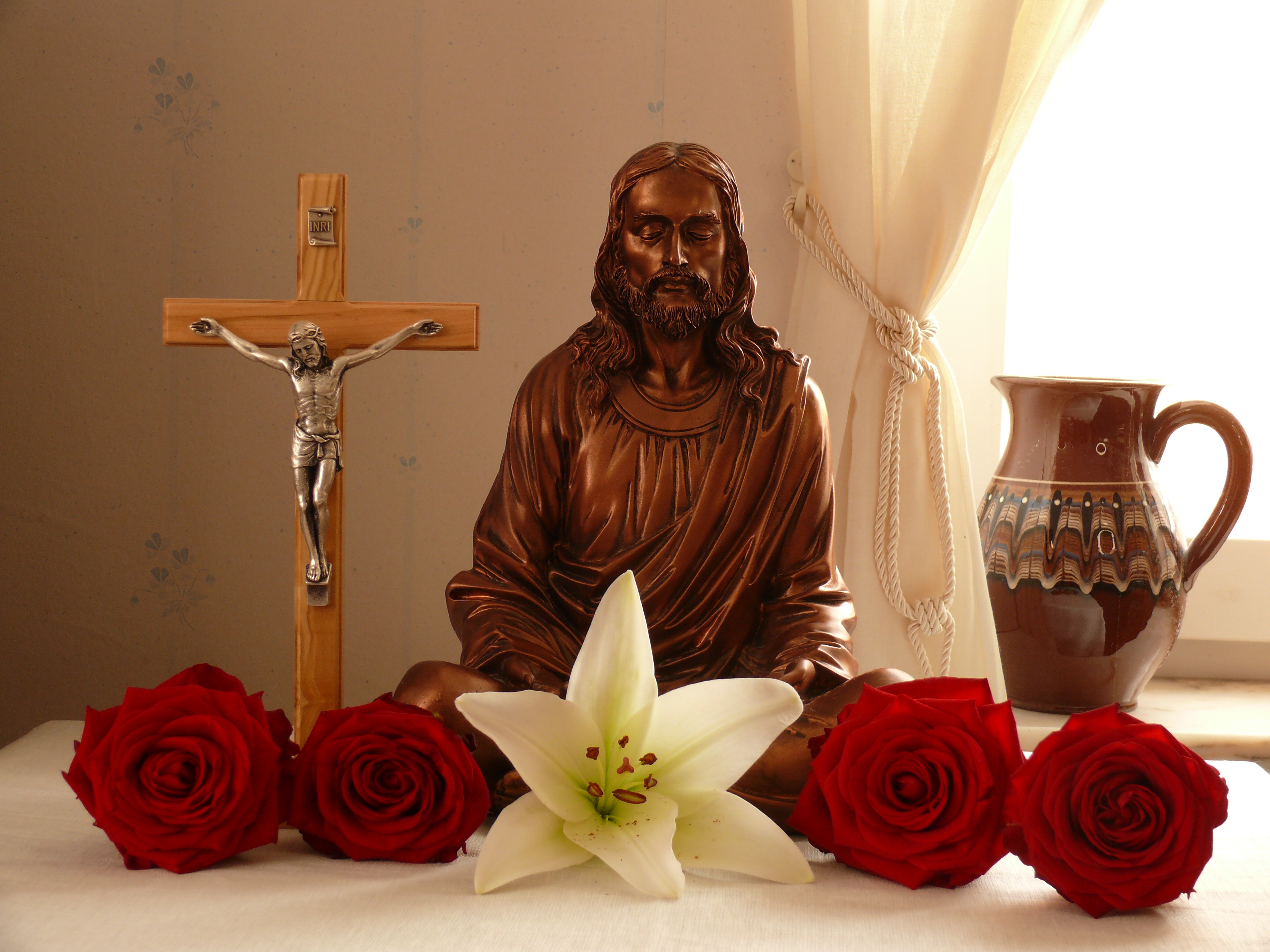 The Peace of Christ; Jesus in a mediative pose, surrounded by roses and white lilys.